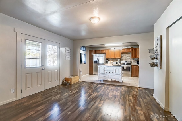 kitchen featuring decorative backsplash, stainless steel appliances, and light hardwood / wood-style flooring