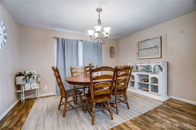 dining space with hardwood / wood-style floors and a chandelier