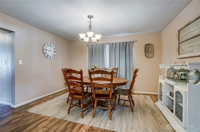 dining space featuring hardwood / wood-style floors and a notable chandelier