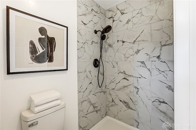 bathroom featuring a tile shower and toilet