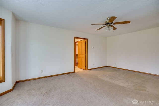 carpeted spare room featuring ceiling fan and a textured ceiling