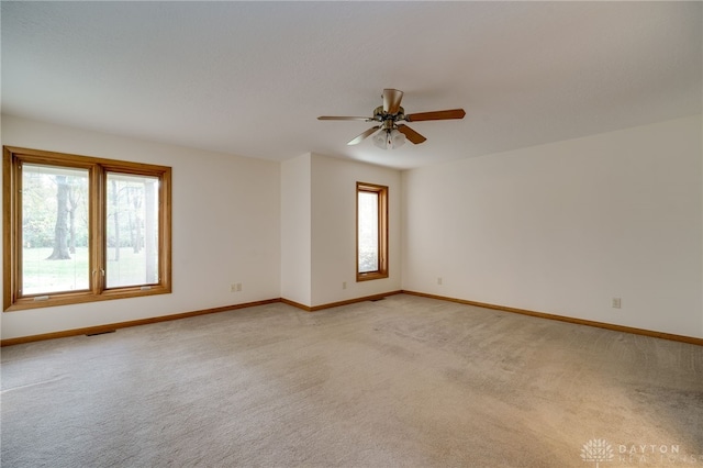 empty room featuring light colored carpet and ceiling fan