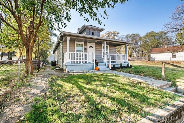 bungalow-style house with fence, a front lawn, a porch, and central AC