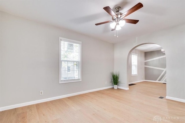 unfurnished room featuring a healthy amount of sunlight, light wood finished floors, and baseboards