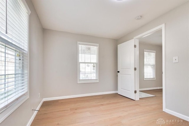 spare room with light wood-style floors and baseboards