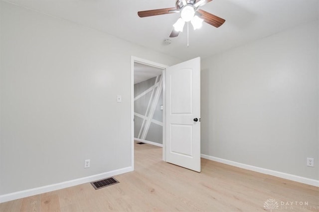 unfurnished room featuring a ceiling fan, baseboards, visible vents, and light wood finished floors