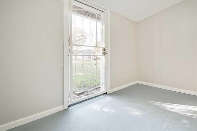 doorway to outside with finished concrete floors and baseboards