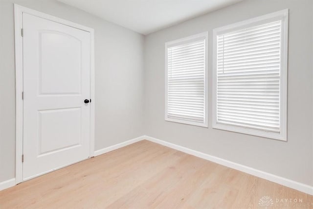 empty room featuring light wood finished floors and baseboards