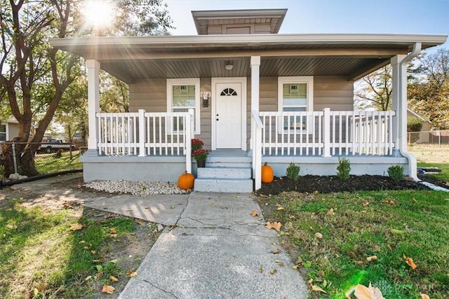 view of front facade featuring covered porch and fence