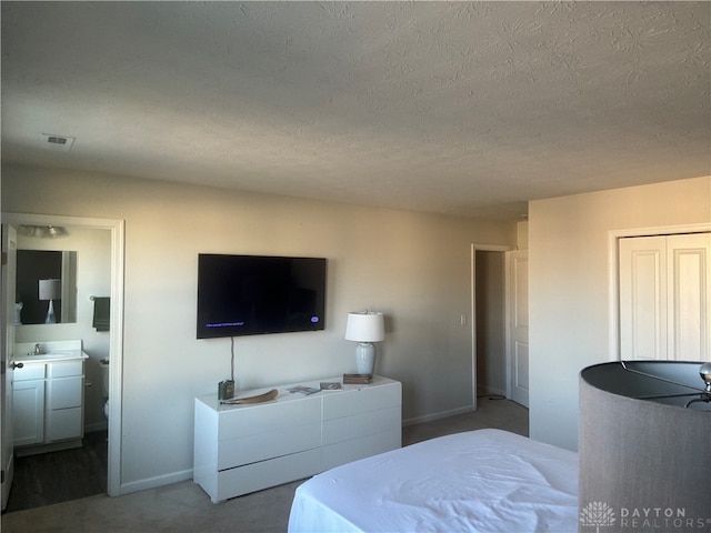 bedroom featuring sink, carpet, and a textured ceiling