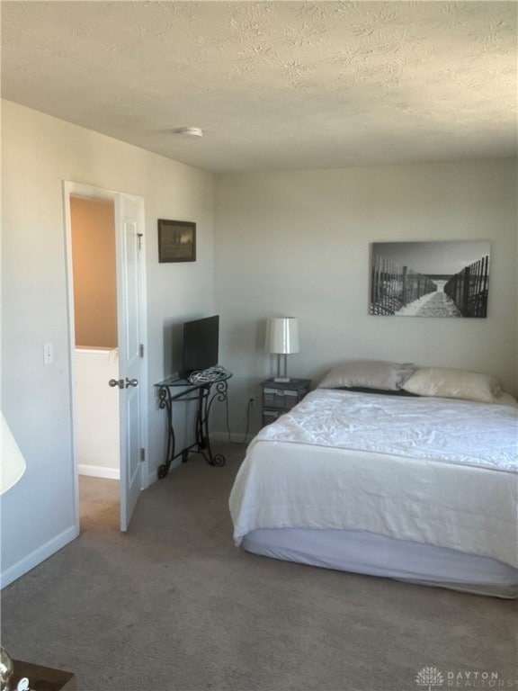 bedroom with a textured ceiling and carpet floors