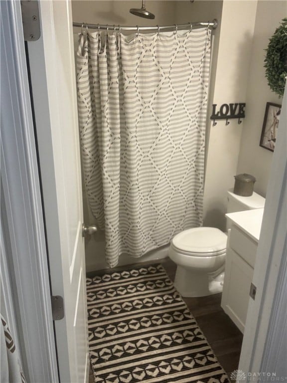 bathroom with hardwood / wood-style flooring, vanity, and toilet