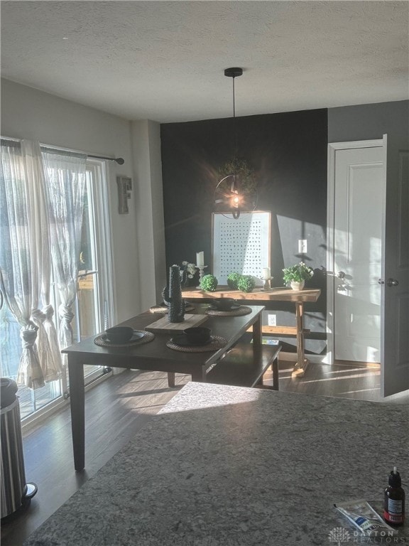 dining area with dark wood-type flooring and a textured ceiling