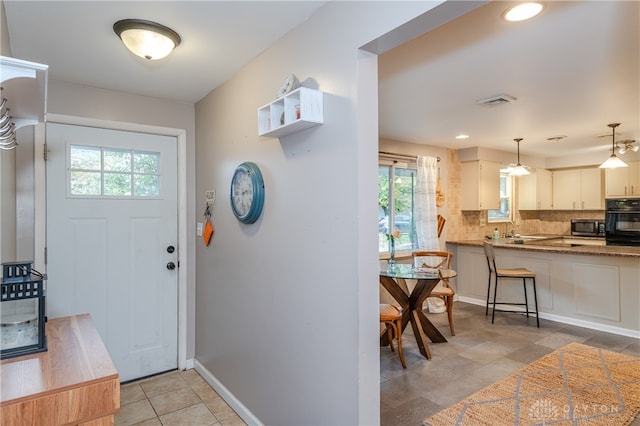 foyer entrance with light tile patterned flooring and plenty of natural light