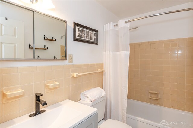 full bathroom with vanity, toilet, tile walls, and shower / tub combo