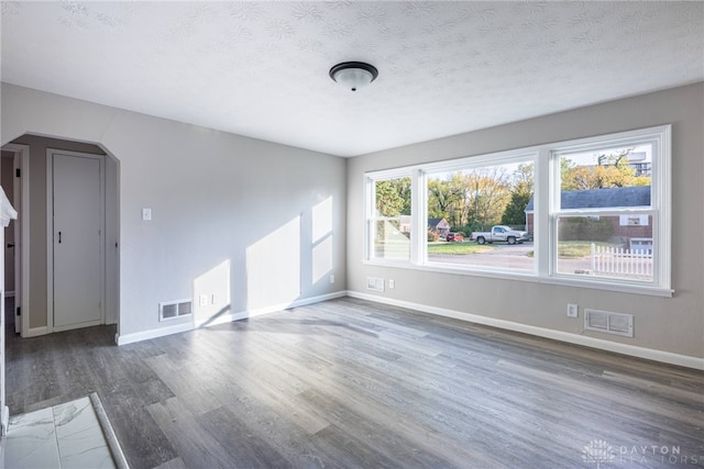 unfurnished room featuring a textured ceiling and dark wood-type flooring