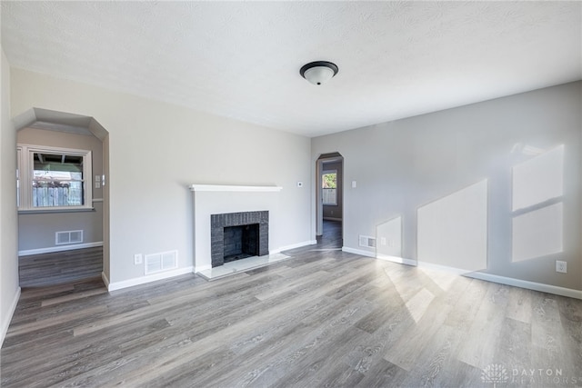 unfurnished living room featuring plenty of natural light, hardwood / wood-style floors, and a fireplace