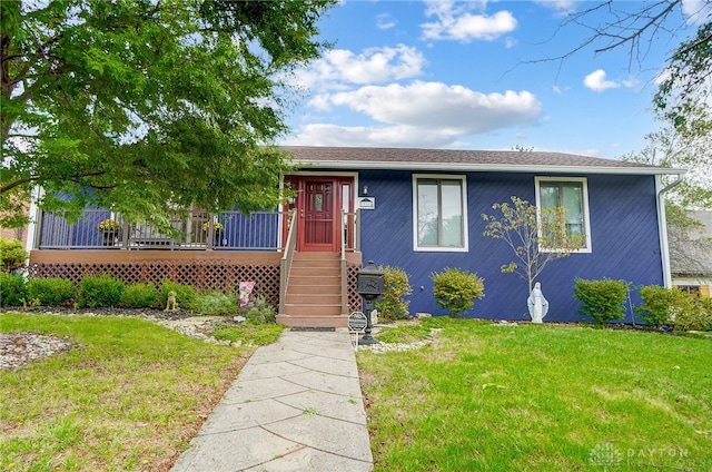 view of front facade with a front lawn and a deck