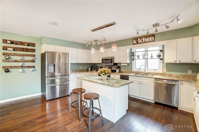 kitchen featuring sink, appliances with stainless steel finishes, a center island, and dark hardwood / wood-style flooring