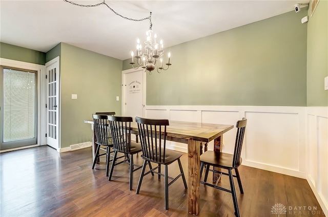 dining area with a notable chandelier and dark hardwood / wood-style flooring