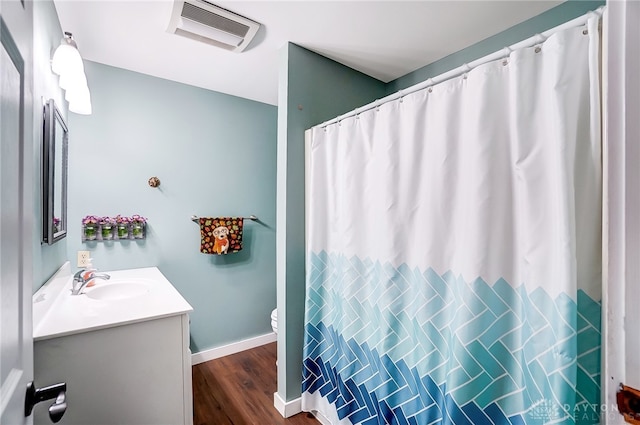 bathroom featuring vanity, hardwood / wood-style floors, and toilet