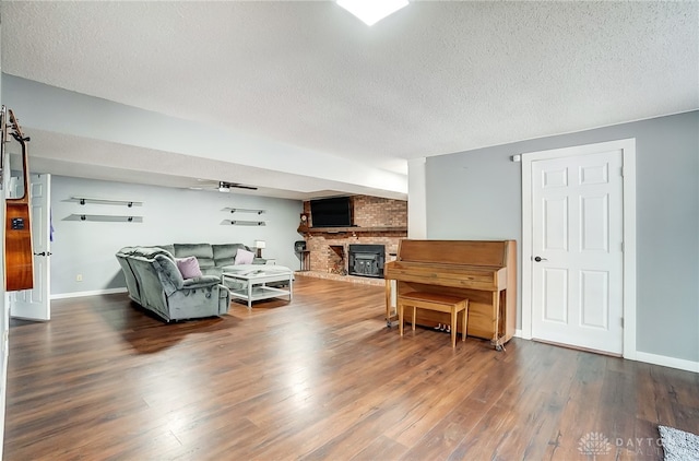 living room featuring a brick fireplace, a textured ceiling, and dark hardwood / wood-style flooring