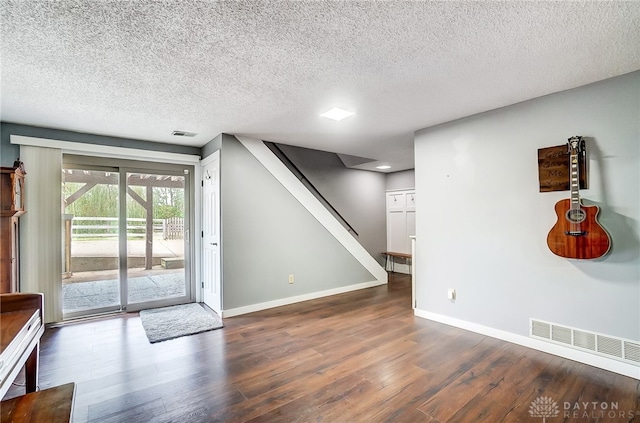 interior space with dark wood-type flooring and a textured ceiling