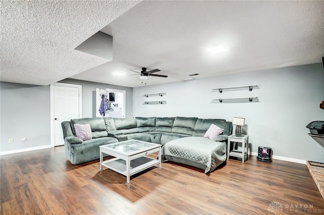 living room with a textured ceiling, hardwood / wood-style flooring, and ceiling fan