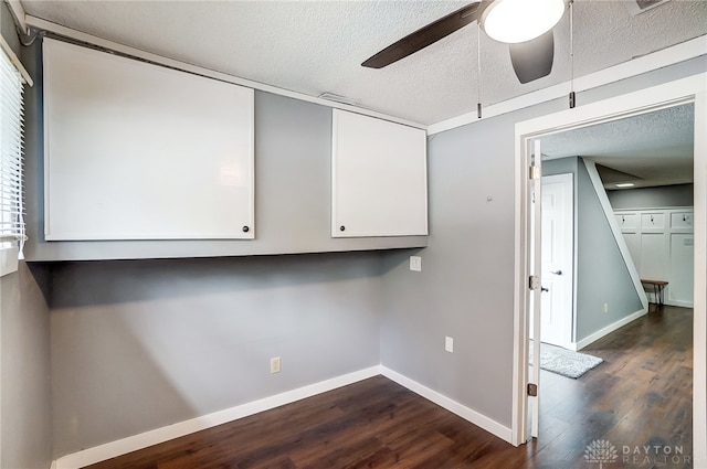 clothes washing area with a textured ceiling, dark hardwood / wood-style floors, and ceiling fan