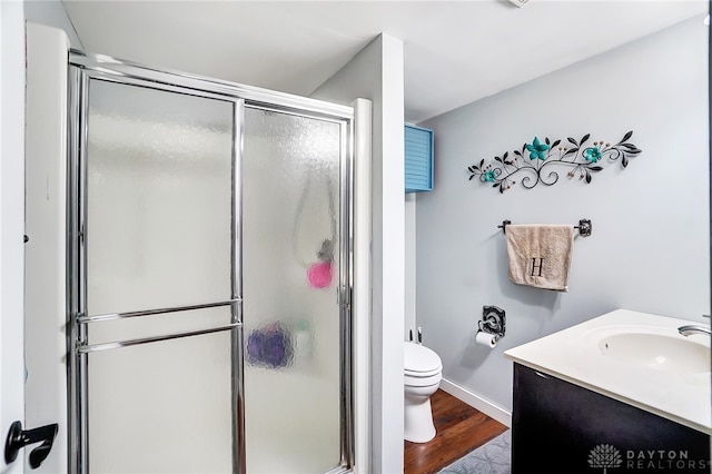 bathroom featuring toilet, hardwood / wood-style floors, walk in shower, and vanity