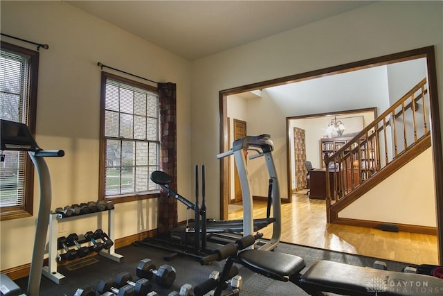 workout area featuring a notable chandelier and hardwood / wood-style flooring