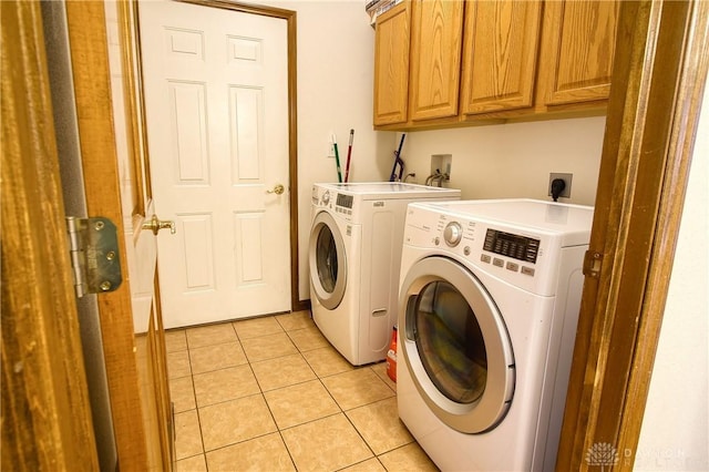 laundry room with light tile patterned floors, cabinets, and independent washer and dryer