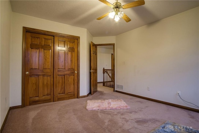 unfurnished bedroom with light colored carpet and ceiling fan