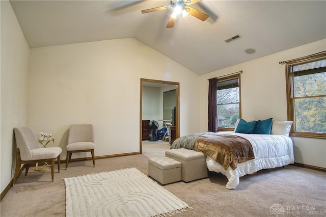 carpeted bedroom featuring a walk in closet, ceiling fan, and vaulted ceiling