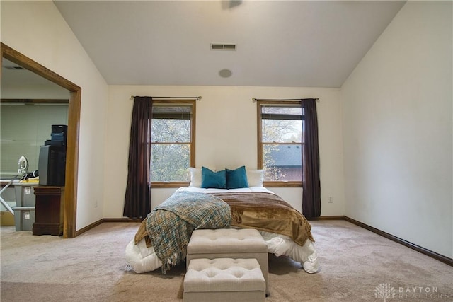 carpeted bedroom with lofted ceiling