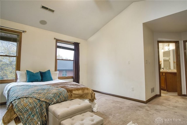 carpeted bedroom with lofted ceiling and ensuite bathroom