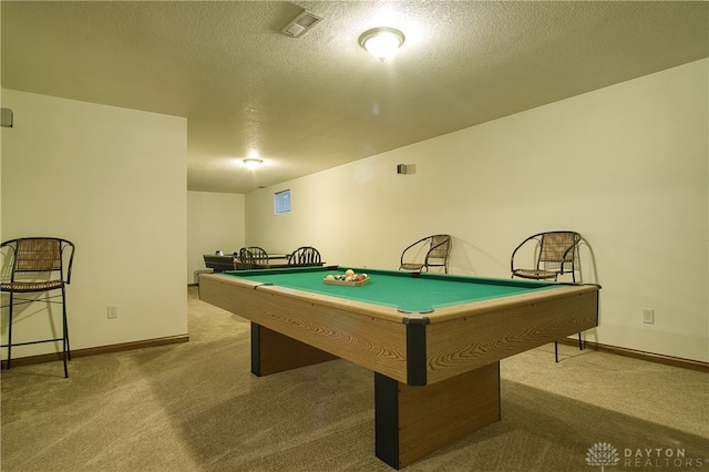 recreation room featuring pool table, a textured ceiling, and light colored carpet