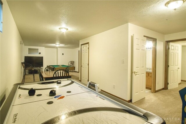 rec room with a textured ceiling, light colored carpet, and pool table