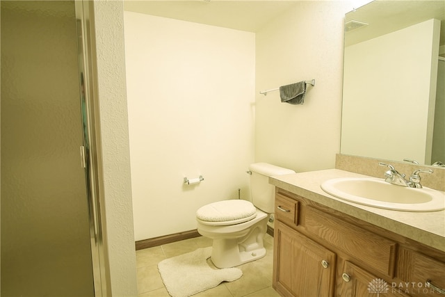 bathroom featuring toilet, an enclosed shower, vanity, and tile patterned floors