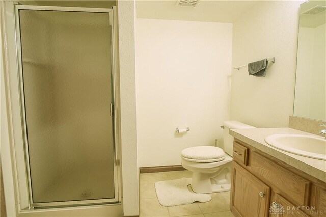 bathroom featuring vanity, tile patterned flooring, a shower with shower door, and toilet