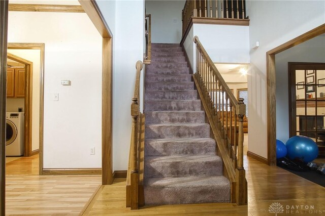 stairway with washer / dryer and hardwood / wood-style floors