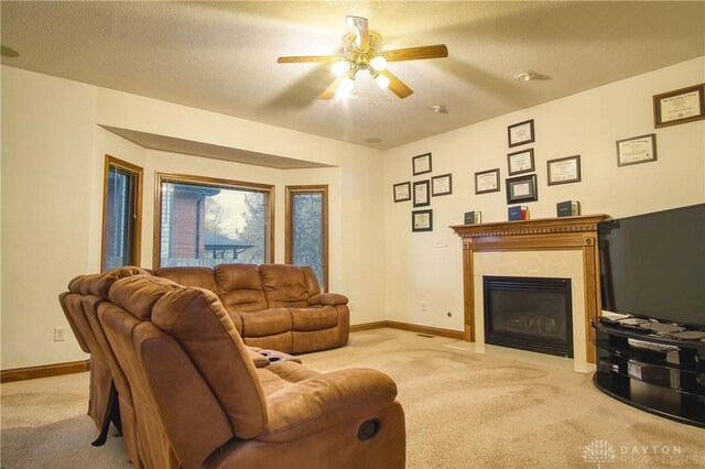 living room featuring ceiling fan, light carpet, and a textured ceiling