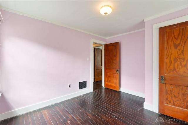 spare room featuring crown molding and dark hardwood / wood-style flooring