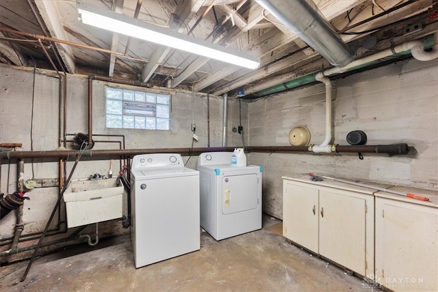 laundry area with sink, washer and dryer, and cabinets