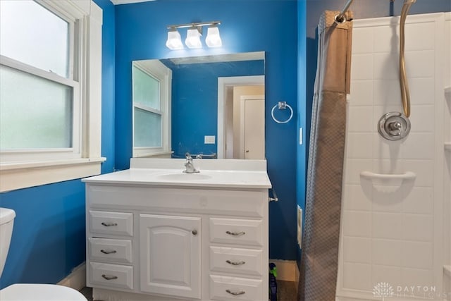 bathroom featuring vanity, a shower with shower curtain, and toilet