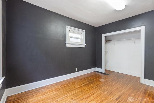 unfurnished bedroom featuring hardwood / wood-style floors and a closet