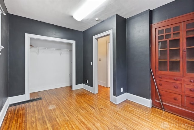 unfurnished bedroom featuring light hardwood / wood-style floors and a closet