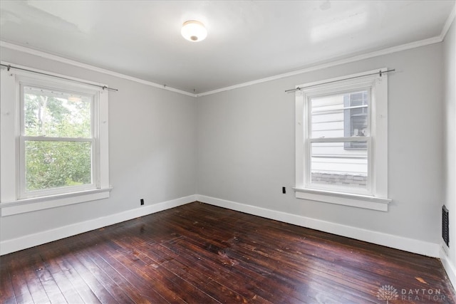 empty room featuring a wealth of natural light, ornamental molding, and wood-type flooring