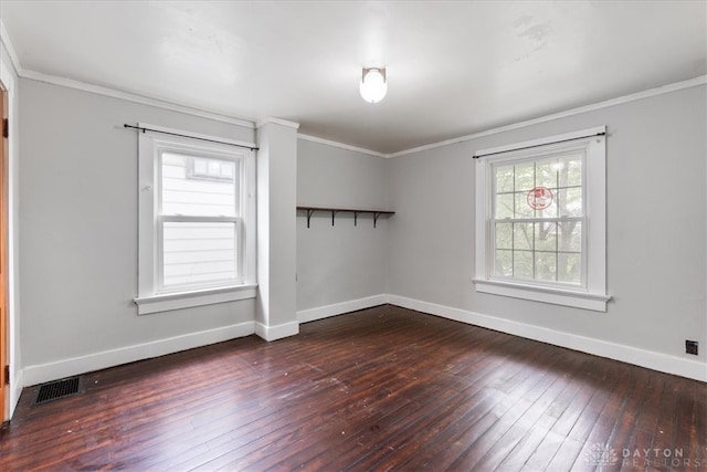 spare room with ornamental molding and dark wood-type flooring