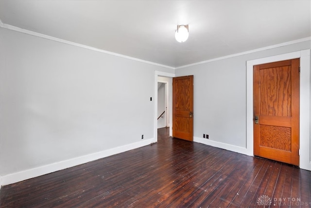 empty room featuring crown molding and dark hardwood / wood-style flooring